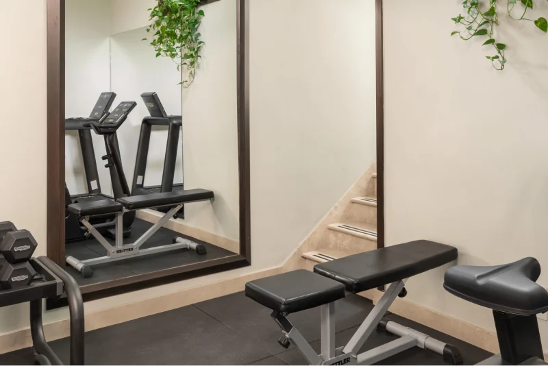 Sala fitness moderna con specchi, pesi e attrezzature cardio per mantenersi in forma durante il soggiorno - Hotel Diocleziano, BZAR hotels a Roma